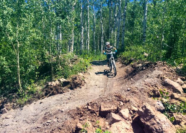 Kid mountain biking dowhill at Powderhorn Bike Park