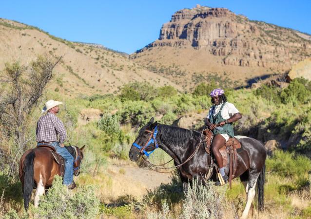 Two men on horses in Little Book Cliffs Wild Horse Range