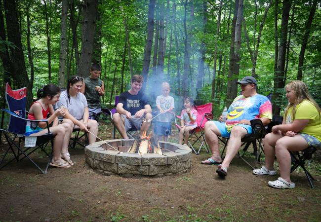 A family roasts marshmallows around a campfire at Branch Brook Campground in the White Mountains.