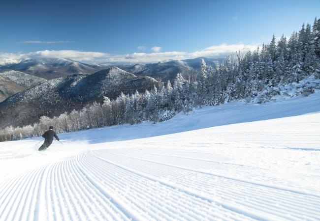 A lone skier heads downhill on a freshly groomed trail at Loon Mountain