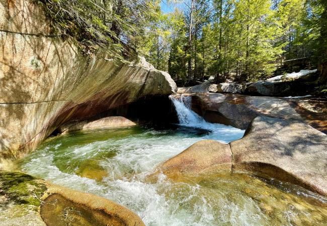 glacial pothole with waterfall and river and trees