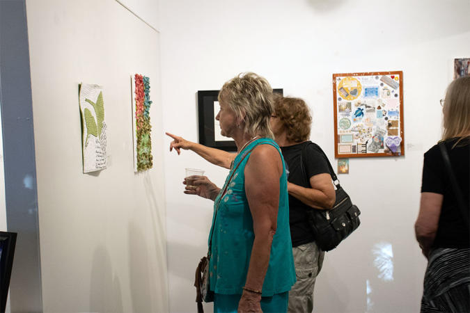 Two Women looking at art on the wall in the Art Center of Western Colorado