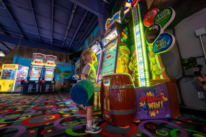 Kid playing arcade game at Bananas Fun Park