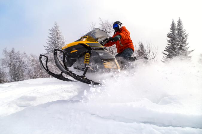 Snowmobiler jumping his sled