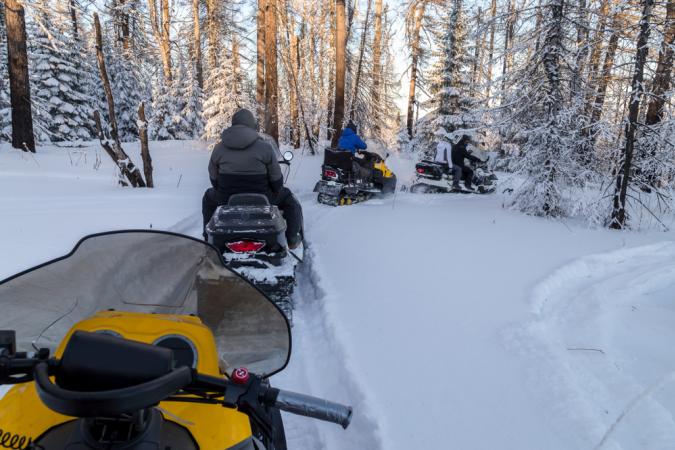 Snowmobilers following each other on Path