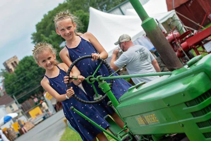 Little girls on a green tractor at the Kutztown Folk Festival