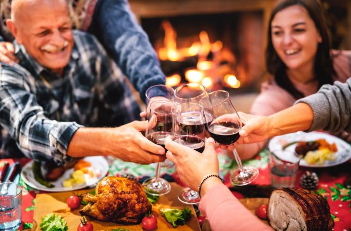 Group of People Toasting next to a Fireplace
