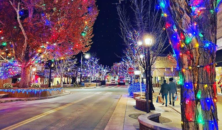 Two People walking down Main Street with Twinkling Lights and Shopping Bags