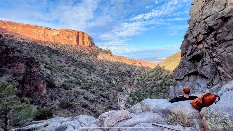 Man Posing on Ute Canyon Trail with Red Rock Walls Around
