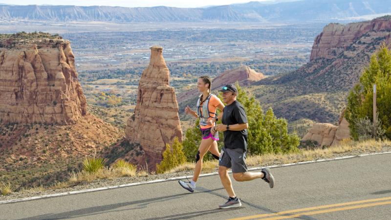 Picture of Two People Running on a Road in Front of the Colorado National Monument