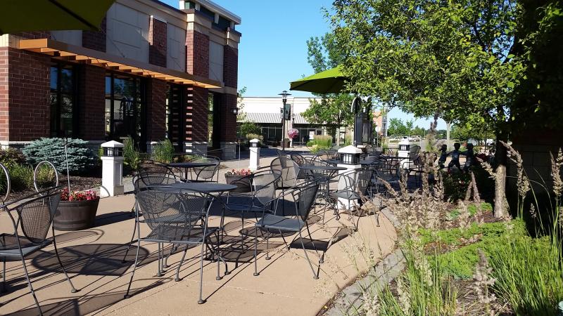Black wire metal tables and chairs sit on the patio at Daily Dose Cafe & Espresso Bar