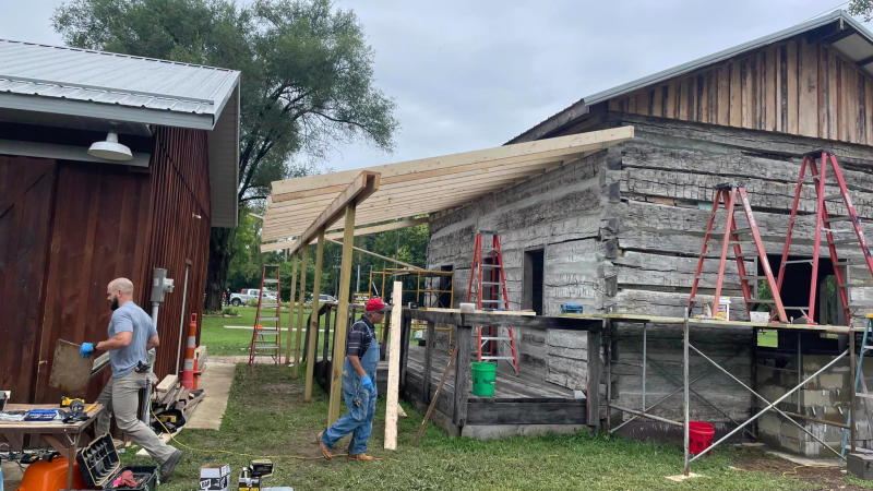 Volunteers work to complete construction on the "new" historic log cabin at Old Town Waverly Park.