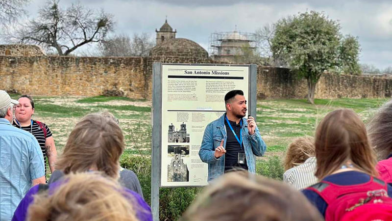 Tour guide speaking in front of San Antonio Missions