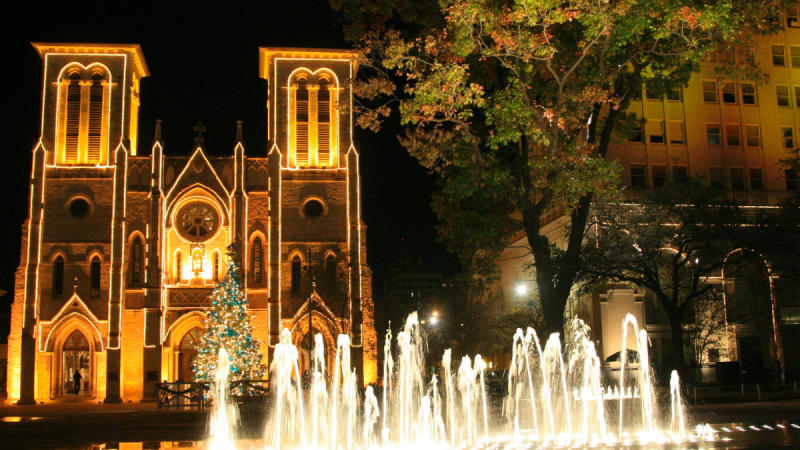 Water fountain in front of lit church at night