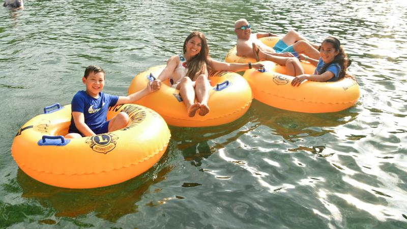 Family with two kids tubing on river