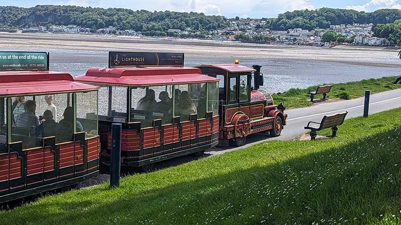 A land train travelling along Swansea Bay.
