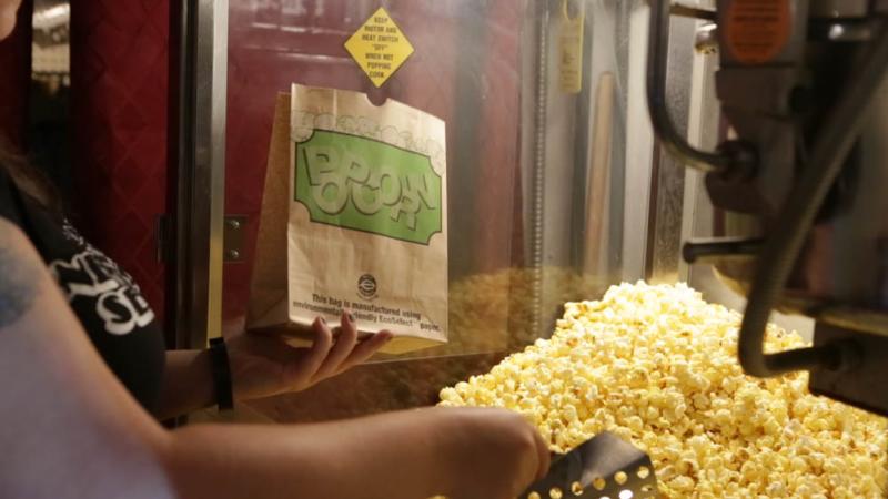 Woman serving popcorn at Kiggins Popcorn