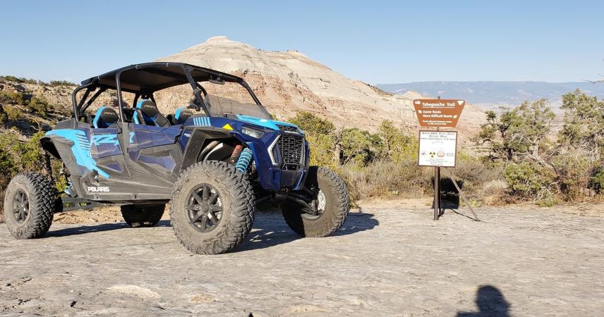 Picture of Blue Jeep in Desert Parked in Front of Sign