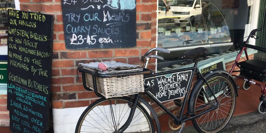 a bicycle outside a butchers with advertising boards