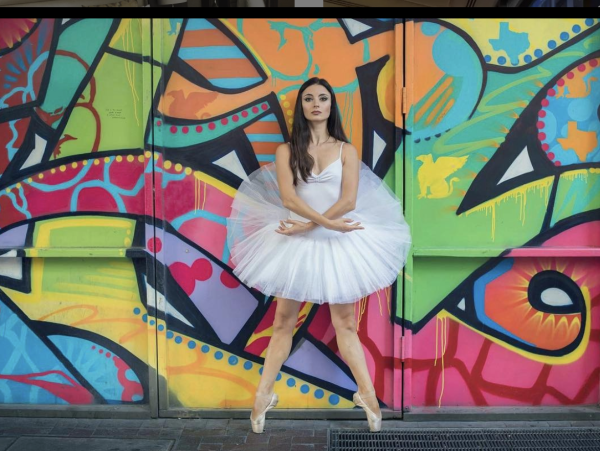 A ballerina stands in front of the mural at JW Marriott Downtown in Houston