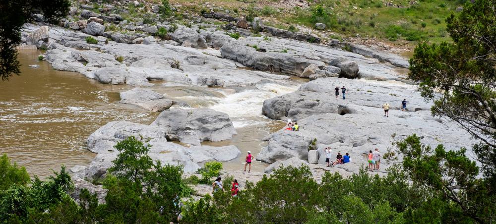 People hiking around rock formations at Pedernales Falls State Park near Austin Texas