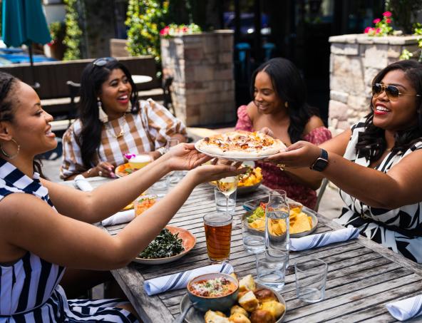 Women sharing food on a restaurant patio