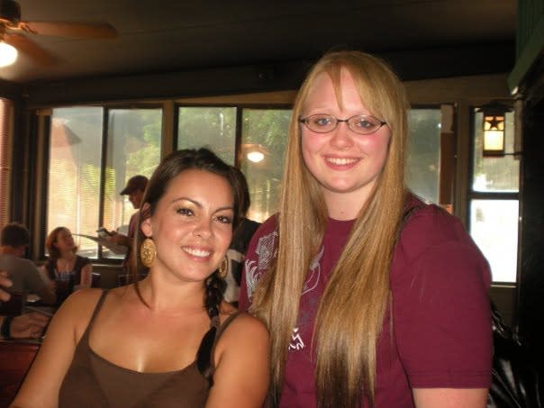 Two young women smile at the camera at River Pub on the banks of the San Marcos River. This photo was taken in 2009 in San Marcos, Texas.