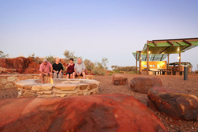 Campers sit by the campfire at Peedamulla Campground in the Pilbara