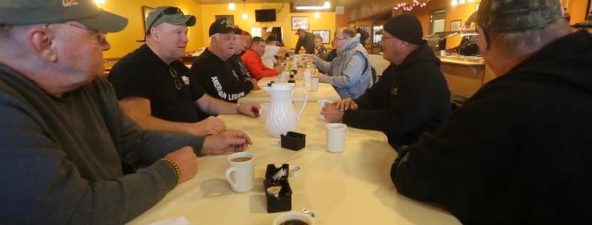 A group sitting and drinking coffee at Veterans Cafe and Catering