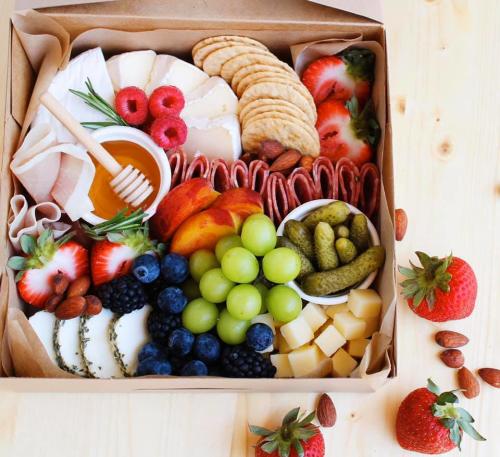 Charcuterie board with cheeses, crackers and fruit from Board and You
