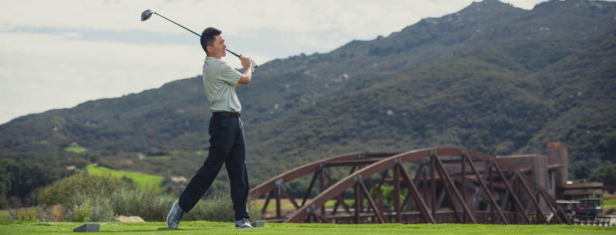 A man swings a golf club