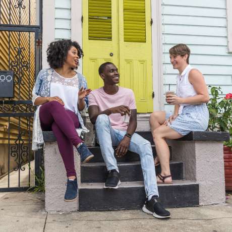 Friends sitting on a porch, talking