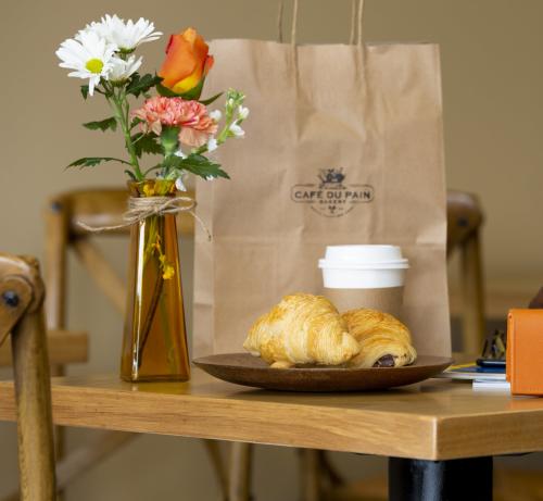 A pair of croissants and a coffee on a table at Cafe Du Pain