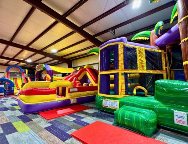 An interior photo of the Monkey House displaying a row of inflatable bounce houses.