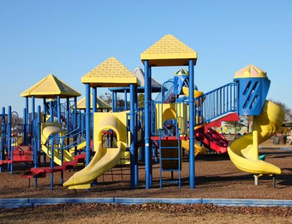 A multi-color playground stands on top of a bed of mulch at Ben Geren Park.