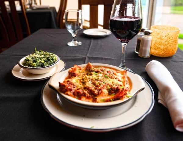 A plate of ravioli sitting on a table paired alongside a salad and glass of red wine at Taliano's in Fort Smith, Arkansas.