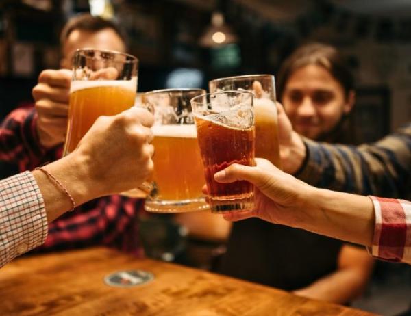 A group of five friends cheer with their beer mugs during a night out in Fort Smith, Arkansas.