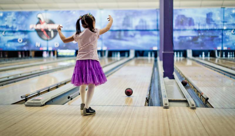young child bowling