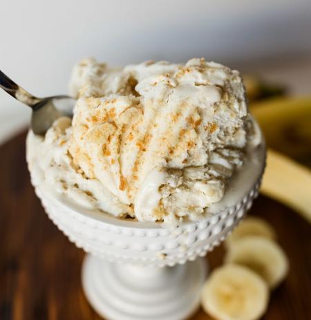 Banana Cream Pie ice cream in a dish with slices of bananas next to the dish.