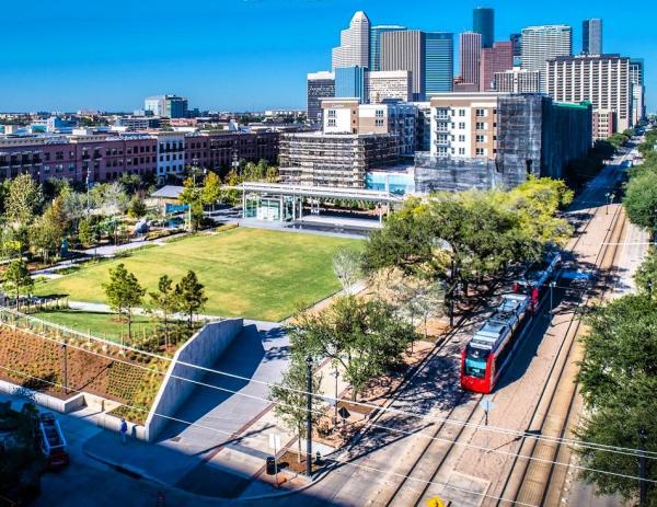 A tram rolls by Midtown Park in the Midtown neighborhood of Houston.