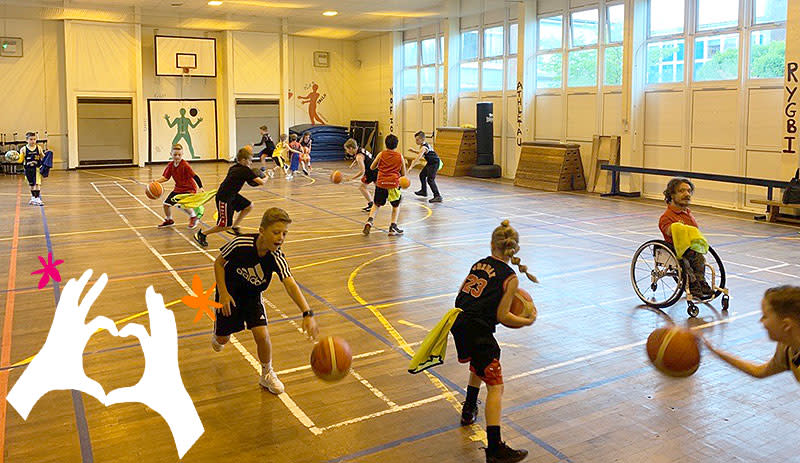 Children playing basket ball in a sports hall.