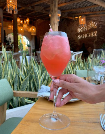 A red cocktail drink on a wooden table