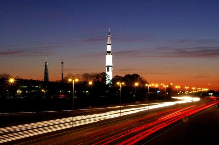 Photo of the U.S. Space & Rocket Center Rocket at night with i565 lit up with car lights