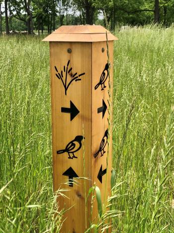 Trail marker at the intersection of Bluestem Bend and Oriole Stroll near the 18-hole disc golf course in W.S. Gibbs Memorial Park.