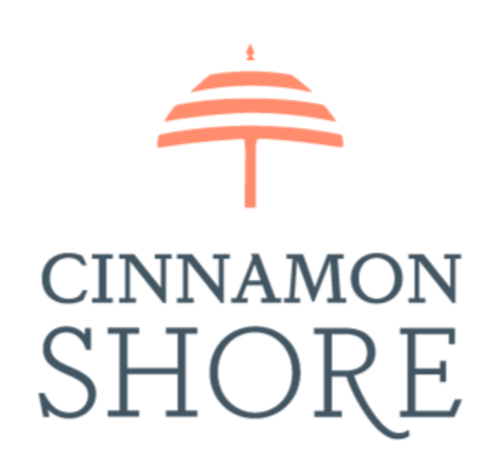 blue text reads Cinnamon Shore. Over top of it is the outline of an umbrella in orange.