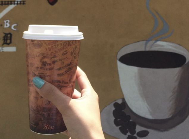 A hand holding a cup of coffee