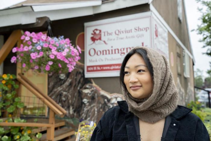 A local Alaskan wearing a cozy qiviut (musk ox wool) scarf outside The Qiviut Shop in Anchorage.