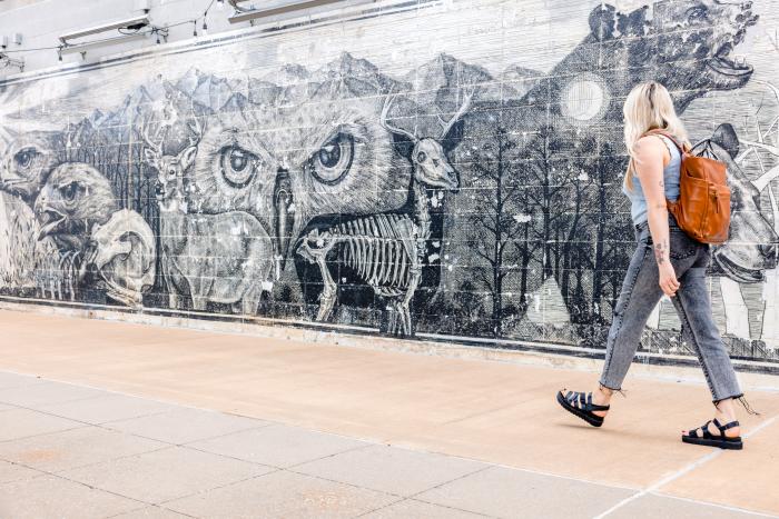 A woman walks by a black and white mural