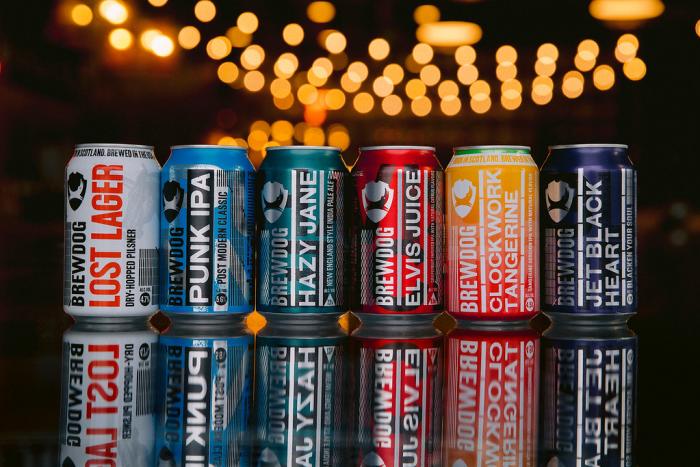 Array of BrewDog canned beer under string lights on bartop