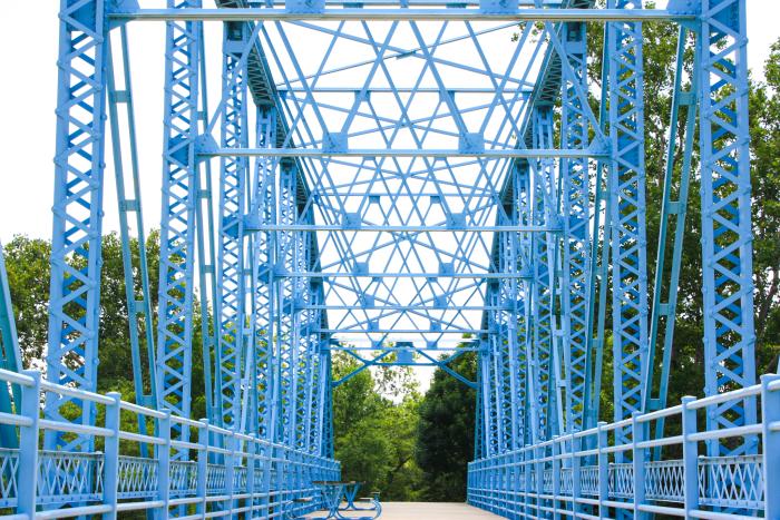 blue bridge at the decatur county park with trees in the background